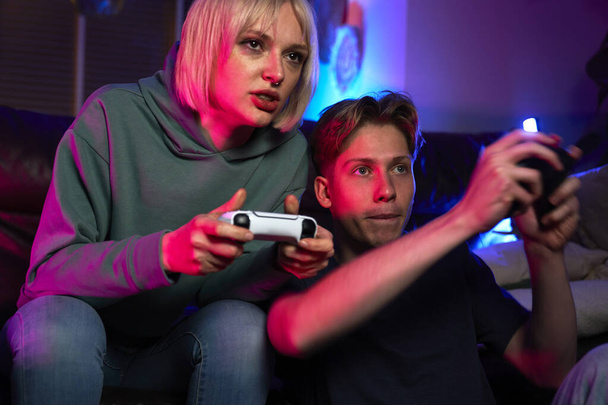 Крупним планом молода кавказька пара грає в відеогру з ігровими майданчиками  - Фото, зображення