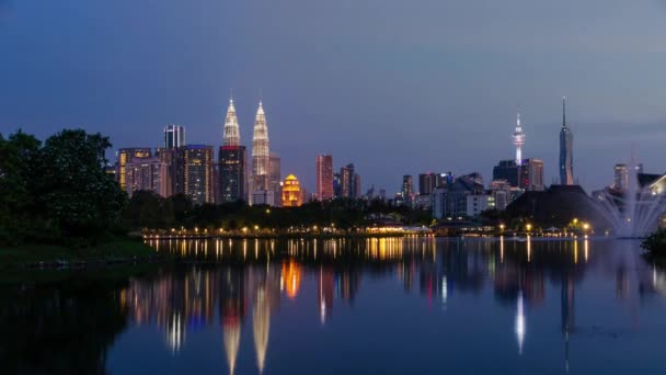 4k aika raukeaa lampi järvi taustanäköalalla Kuala lumpur kaupungin keskustaan monia kohoava pilvenpiirtäjä ja Twin Towers auringonlasku kaunis vaniljataivas. Timelapse kaupunki klcc Malesiassa - Materiaali, video