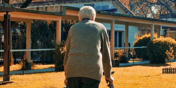 Vanhukset eläkkeellä mies kävelijä ottaa kävellä puutarhassa. - Valokuva, kuva