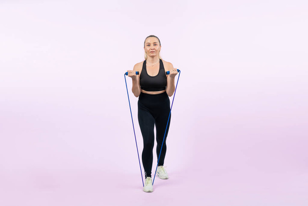 Vücut uzunluğu tam, atletik ve sportif yaşlı kadın izole edilmiş arka planda halat egzersizi yapıyor. Sağlıklı aktif fizik ve vücut bakımı son sınıf öğrencileri. Etki - Fotoğraf, Görsel