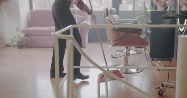Inkivääri tyttö moppaa lattia kampaus studio jälkeen aliarvostus, kuorma liike - Materiaali, video