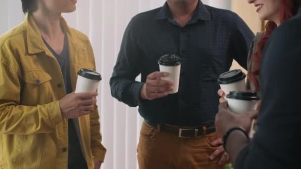 Gehakt schot van collega 's drinken van koffie tijdens het ontbijt in het kantoor allemaal samen - Video