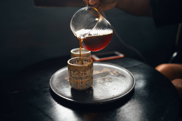 Černá káva se nalévá do keramického hrnku.Ranní káva - Fotografie, Obrázek