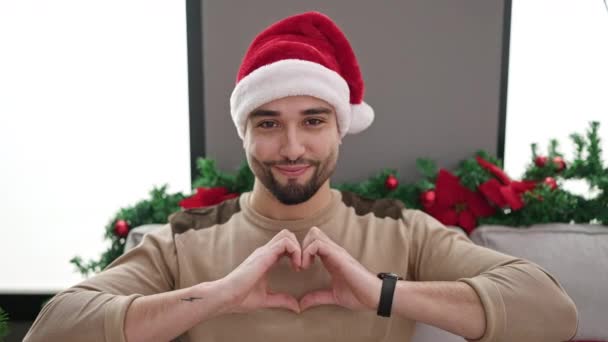 Young arab man by christmas tree at home - Footage, Video