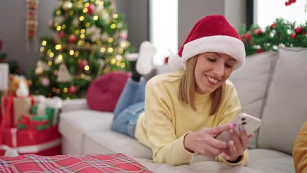 Mujer rubia joven por árbol de Navidad en casa - Imágenes, Vídeo
