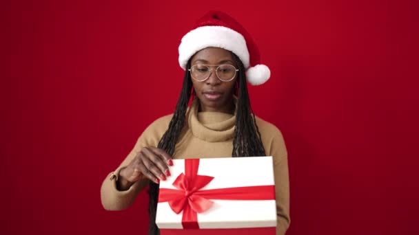 Femme africaine déballer cadeau sur fond rouge - Séquence, vidéo