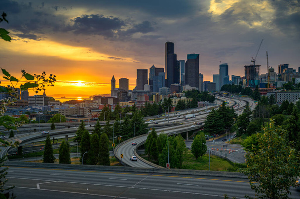 Dramatic sunset over the Seattle downtown skyline, with traffic on the I-5 and I-90 freeway interchange, viewed from Dr. Jose Rizal Bridge. - Photo, Image
