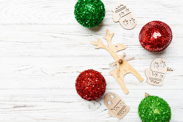 Nieuwjaarscompositie gemaakt van kerstballen, rendieren en andere decoraties op houten ondergrond. Kerstconcept met lege ruimte voor uw ontwerp. - Foto, afbeelding