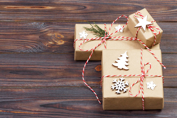 Trois boîtes festives en papier craf décoré avec des flocons de neige et étoile sur table en bois. Vue du dessus
. - Photo, image