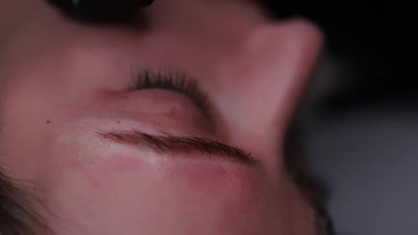 Close-up van een model wenkbrauw wordt geborsteld met een wenkbrauw borstel  - Video