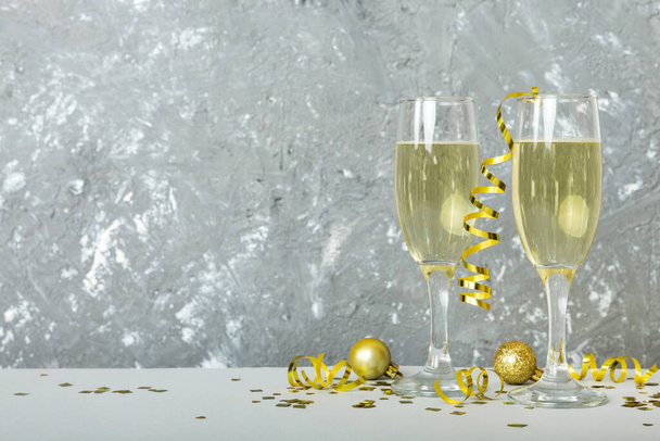 Champagne glasses and christmas decor on colored holiday background. Flat lay New Year decorations. - Foto, imagen
