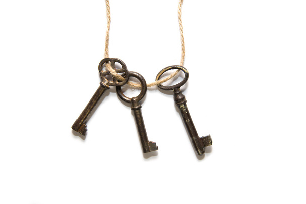 Trzy stare klucze związane z lina na białym tle - Zdjęcie, obraz