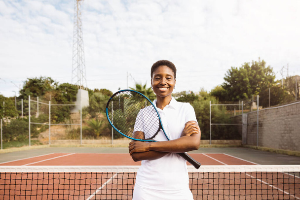 Portrait d'une jeune belle femme avec des vêtements de tennis et raquette dans un court de tennis prêt à jouer un jeu. - Photo, image