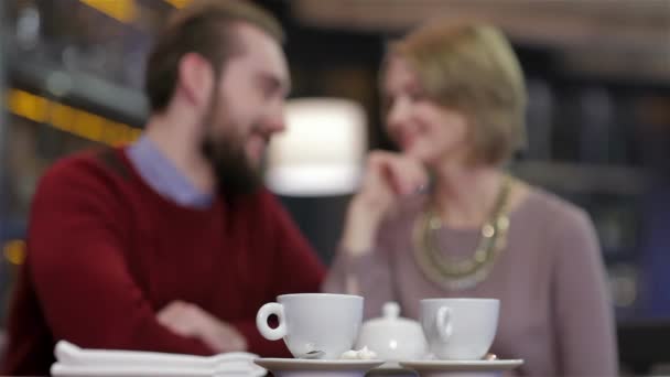 Two young people in cafe enjoying the time spending with each other. Celebrating a Valentines Day at a restaurant. Young couple sitting in a cafe drinking coffee and tea. Enamored a gala dinner for - Footage, Video