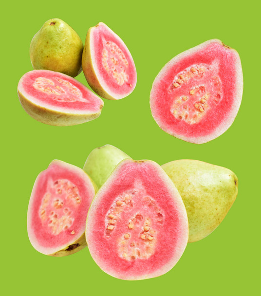 Розовый или красный Гаува фрукты изолированы с обрезкой путь на зеленом фоне, без тени, здоровые тропические свежие фрукты - Фото, изображение
