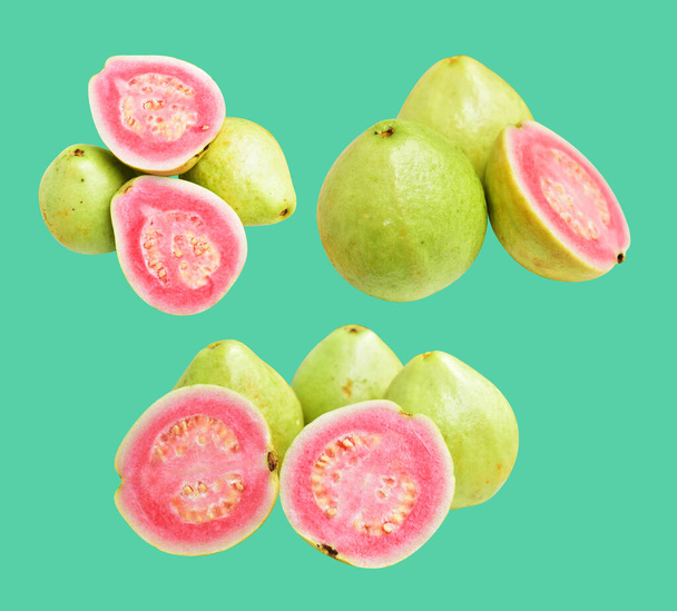 Рожеві або червоні плоди Гави ізольовані відсічним контуром на зеленому фоні, без тіні, здорові тропічні свіжі фрукти - Фото, зображення