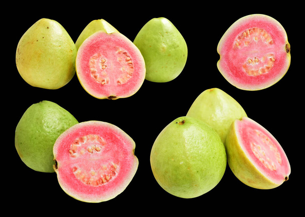 Рожеві або червоні плоди Гави ізольовані відсічним контуром на чорному тлі, без тіні, здорові тропічні свіжі фрукти - Фото, зображення