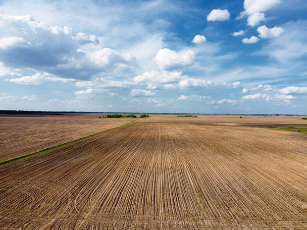 Beautiful cloudy sky over plowed farm fields. Agricultural landscape. - Photo, Image