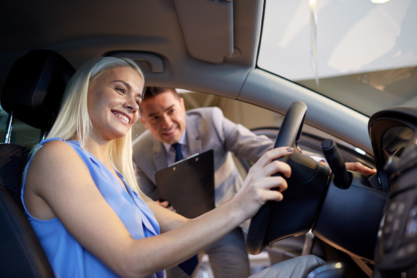 happy woman with car dealer in auto show or salon - Foto, Bild