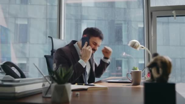 Homem de negócios emocional louco chamando sentado escritório de luxo. Gerente frustrado frustrado jogando telefone na mesa de trabalho desapontado perda de negócios. Chefe irritado batendo mesa sentindo desespero por conversa telefônica - Filmagem, Vídeo