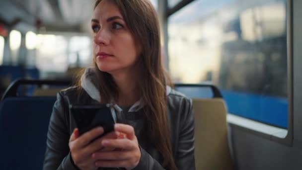 Veřejná doprava. Žena v tramvaji používá smartphone chatování a smskování s přáteli, zpomalený film. Město, městská, doprava. - Záběry, video