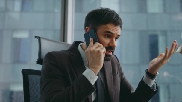 Dissatisfied director arguing in cellphone worried work results close up. Angry bearded businessman shouting in smartphone sitting office. Annoyed nervous ceo manager quarelling on trouble by phone. - Footage, Video