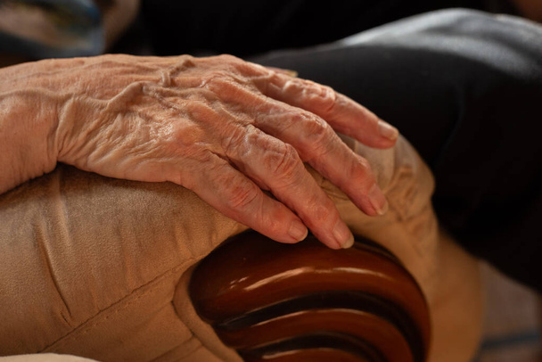 zblízka osoby ruce na židli, starší koncepce, vrásky - Fotografie, Obrázek