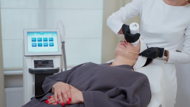 Медленный снимок косметолога, использующего охлаждающий гель для лечения лица лазером. Подготовка кожи перед использованием аппаратной косметологии для омоложения - Кадры, видео