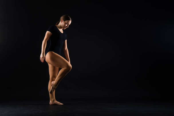 Retrato de una hermosa joven gimnasta entrenando ejercicio de calilistenia con elemento acrobático - Foto, imagen
