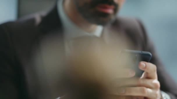Biznesmen trzyma telefon serfując portale społecznościowe w miejscu pracy. Uśmiechnięty biznesmen czytający wiadomości w biurze telefonii komórkowej. Szczęśliwy pracownik cieszyć przyjazny czat na smartfonie - Materiał filmowy, wideo