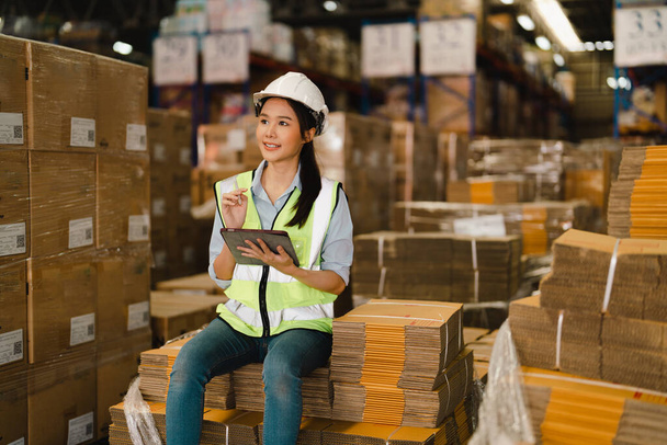 Portret van Aziatische vrouw magazijn supervisor werken distributie magazijn aan het beheer van de inventaris en logistiek. - Foto, afbeelding