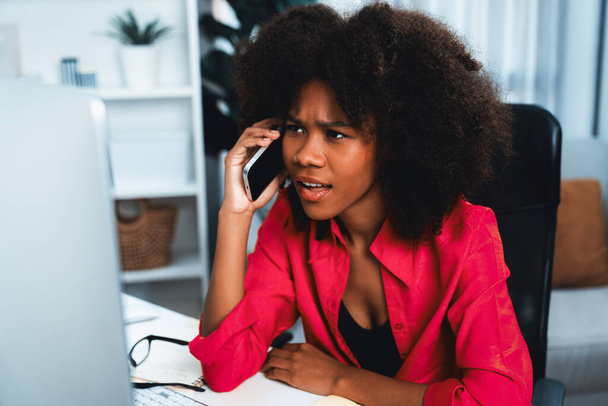 Afrikalı bir kadın telefonda iş arkadaşı ya da arkadaşıyla konuşuyor ve mutlu bir yüzle ekrana bakıyor. Şirketteki iyi haber hayatına sahip bir iş bulma konusunda başarı. Tatlandırıcı. - Fotoğraf, Görsel