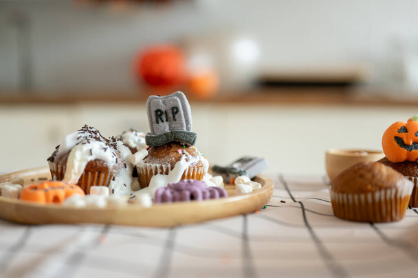 Közelkép a halloweeni sütikről a konyhaasztalon. Halloween kísérteties szezon, desszertek, édes, kísérteties süti ötlet - Fotó, kép