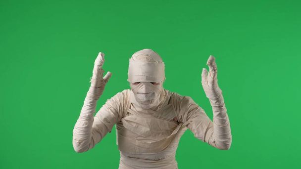 Green screen isolated chroma key photo capturing a mummy shaking its arms as if its dancing, showing confusion or attracting attention. Mock up, workspace for your promotion clip or advertisement. - Fotó, kép