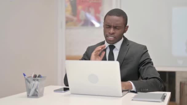 Африканский бизнесмен с болями в шее работает над ноутбуком в офисе - Кадры, видео