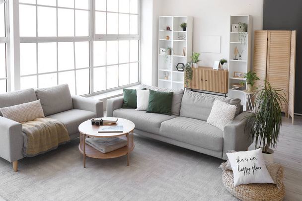 Sisätilojen valoisa olohuone kodikas harmaa sohvat ja sohvapöytä - Valokuva, kuva
