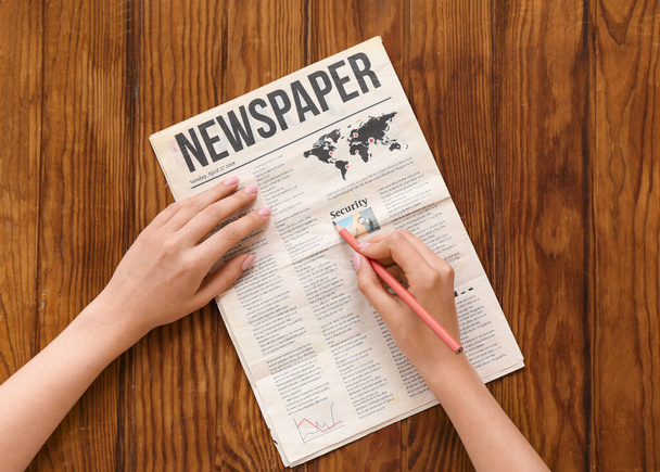 Žena označení textu v novinách s tužkou na dřevěném pozadí - Fotografie, Obrázek