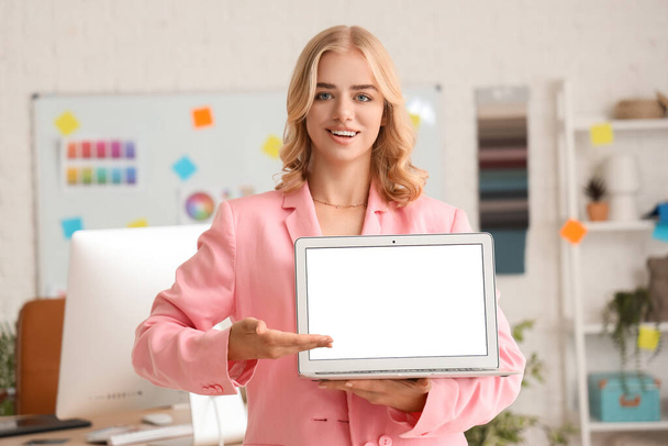 Vrouwelijke interieurontwerper met laptop op kantoor - Foto, afbeelding