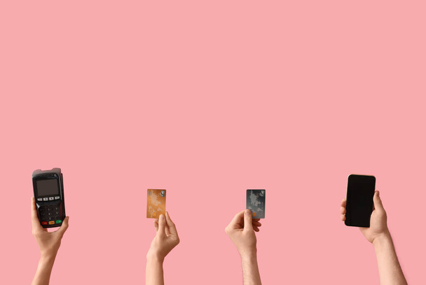Vrouwen met creditcards, betaalterminal en mobiele telefoon op roze achtergrond - Foto, afbeelding