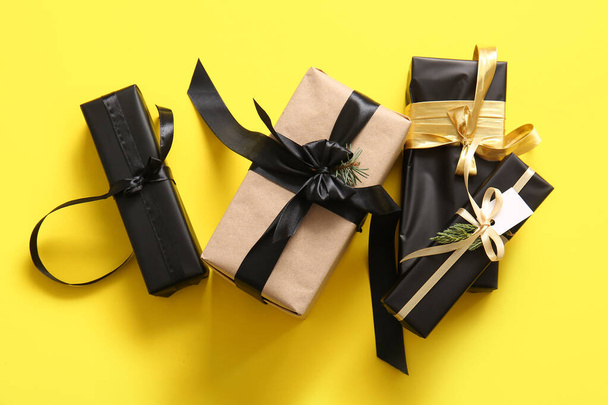 Cajas de regalo con rama de árbol de Navidad sobre fondo amarillo - Foto, imagen