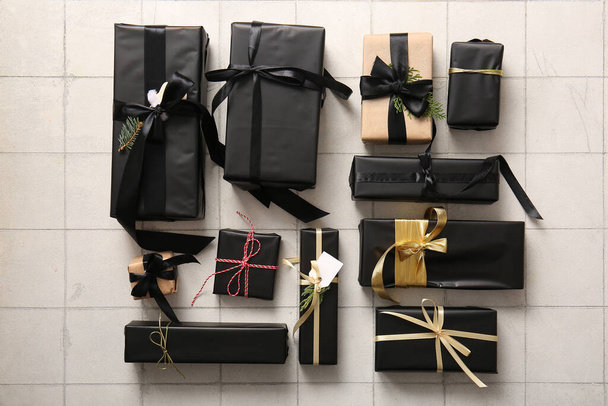Molte scatole regalo con rami di albero di Natale su sfondo di piastrelle bianche - Foto, immagini