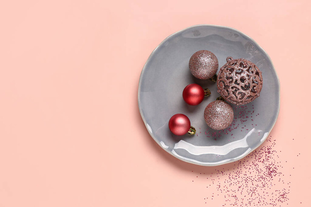 Piatto con palline di Natale e coriandoli su sfondo rosa - Foto, immagini