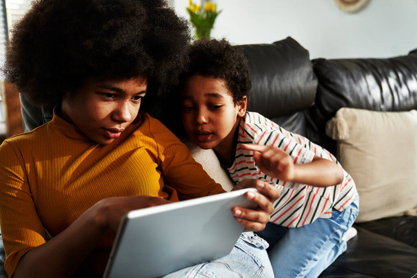 Δύο παιδιά περιηγούνται ψηφιακή ταμπλέτα στο σαλόνι - Φωτογραφία, εικόνα