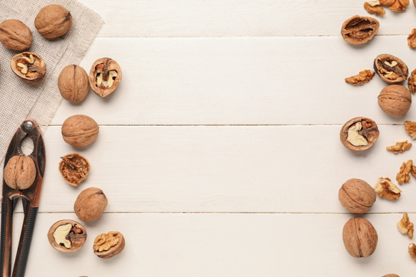 Каркас з волоських горіхів і луску на білому дерев'яному фоні - Фото, зображення