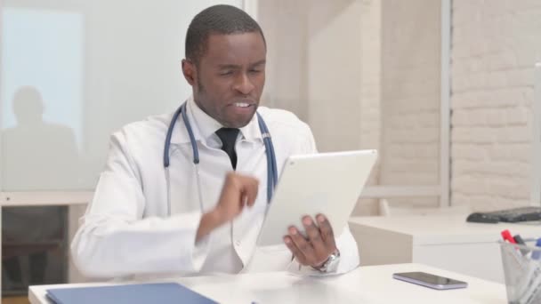 Afrykański lekarz robi czat wideo na tablecie w klinice - Materiał filmowy, wideo