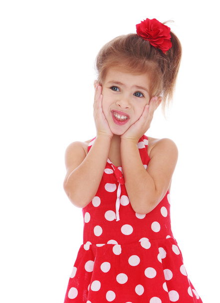 μικρό κορίτσι σε ένα κόκκινο φόρεμα με λευκό πουά διατηρούνται στα χέρια - Φωτογραφία, εικόνα