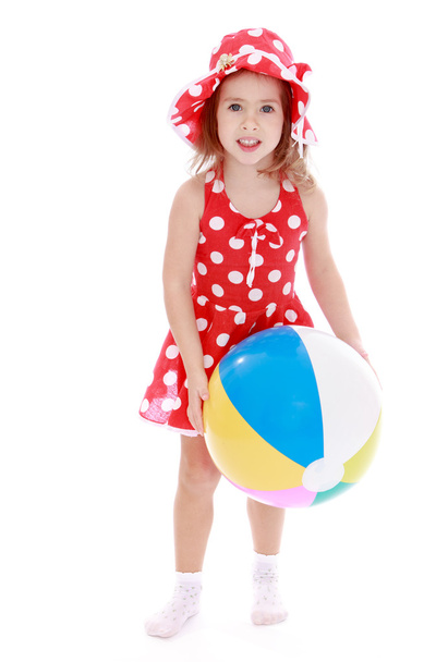 Girl in a red summer dress and hat holding a beach ball - Foto, immagini