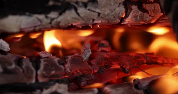 Quemaduras de fuego en la chimenea y el carbón se extrae lentamente. Carbones y cenizas al rojo vivo en la oscuridad que se desvanece - Metraje, vídeo
