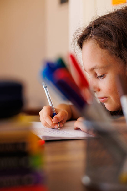 Gyerekkéz közelről. a gyermek ceruzával gyakorolja a levelezést. A gyerek megtanulja, hogy írjon egy jegyzetfüzetbe. óvodai nevelési koncepció. - Fotó, kép