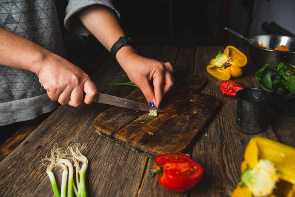 Girl cutting vegetables on a wooden board - Photo, Image